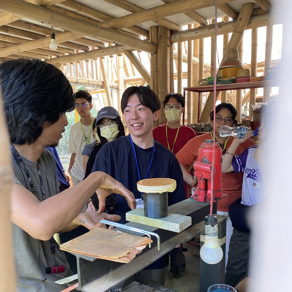 Guests watching a cow dung clay upcycling demonstration