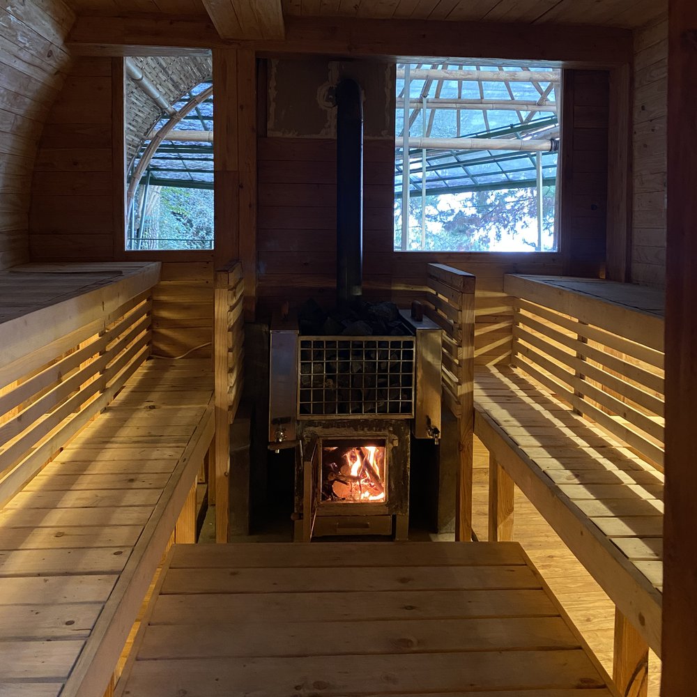 Wood-fired sauna interior with the stove and fire lit
